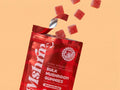 MshrooM FX Extra Strength Bulk Mushroom Gummies Strawberry, 50 count, red resealable bag, opened at an angle, with eight sugar-coated red gummy pieces bursting out of the top, on a peach background, showing vegan, gluten-free, no high fructose corn syrup seal, and 50 pieces per bag label.